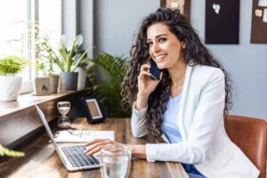 A woman is sitting at a desk using a laptop