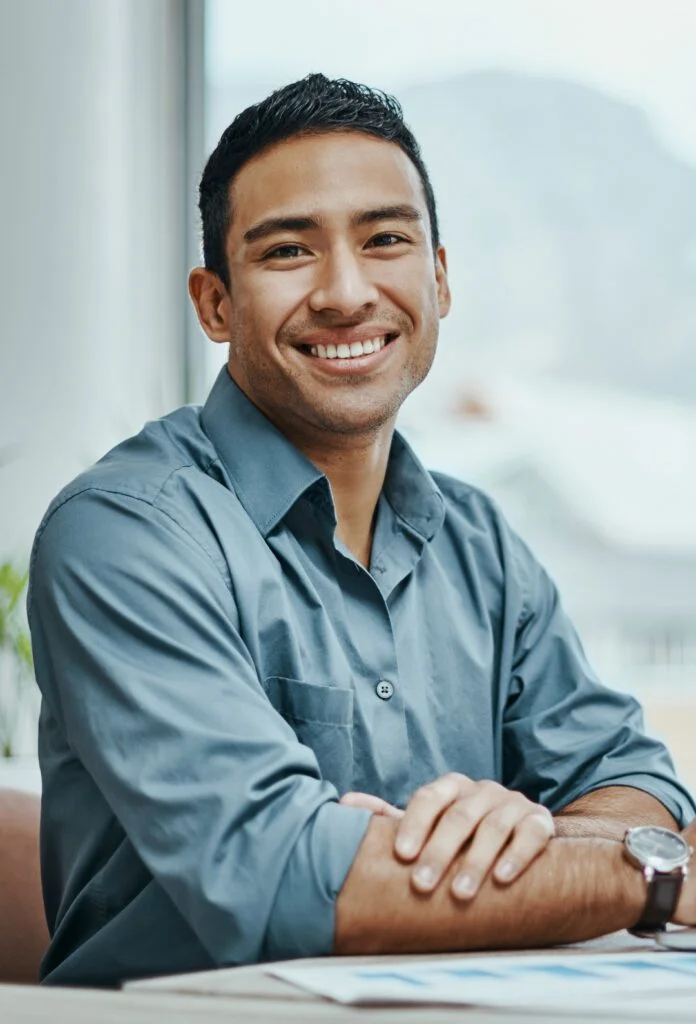 A man wearing a gray shirt and smiling